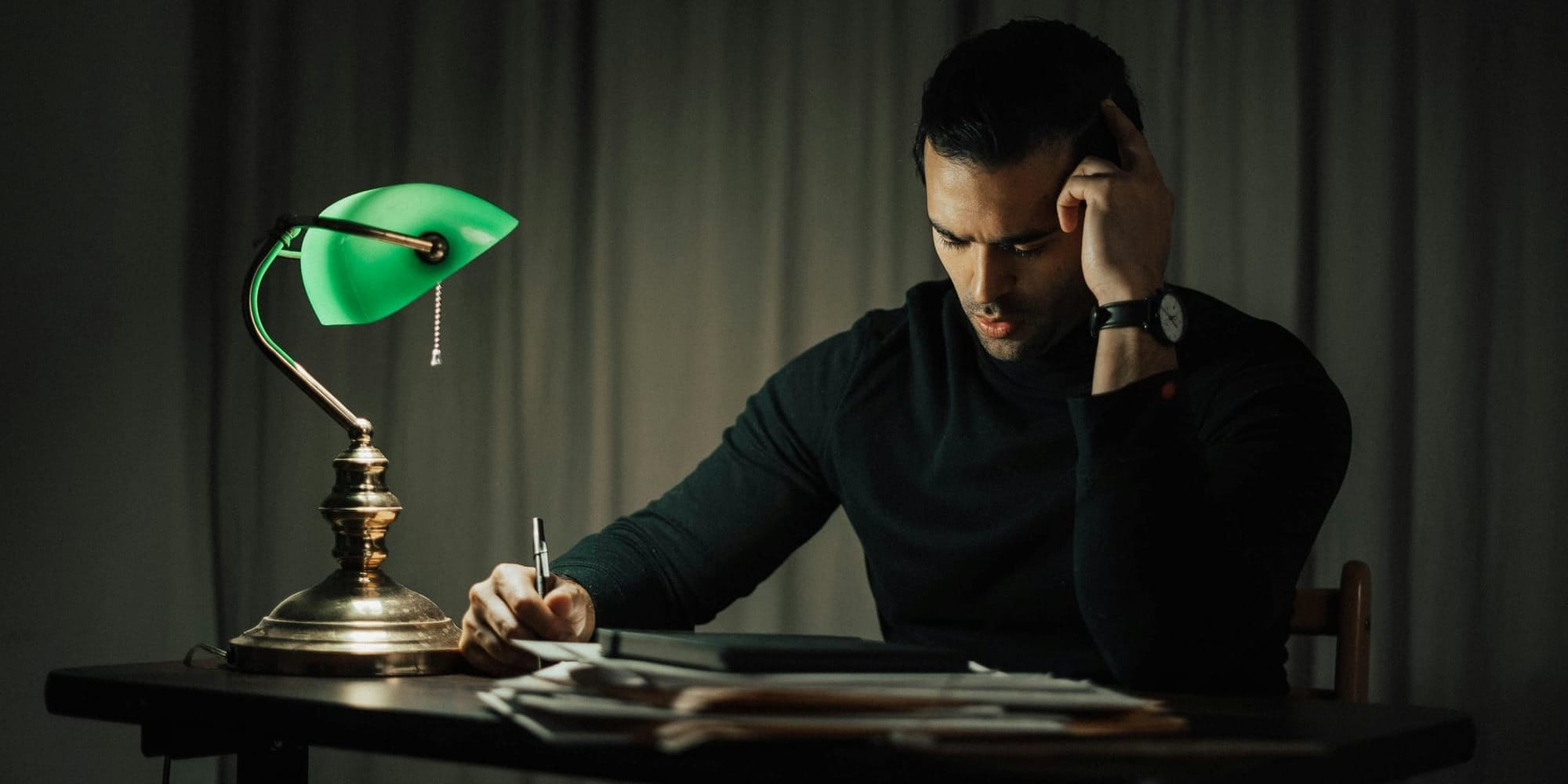 thoughtful man sitting at a desk and reading