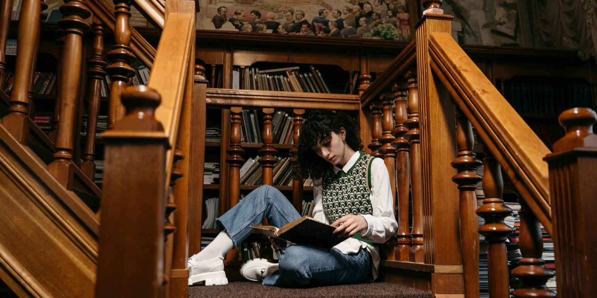 woman sitting on the stairs and reading an old book