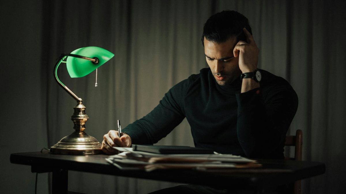 thoughtful man sitting at a desk and reading
