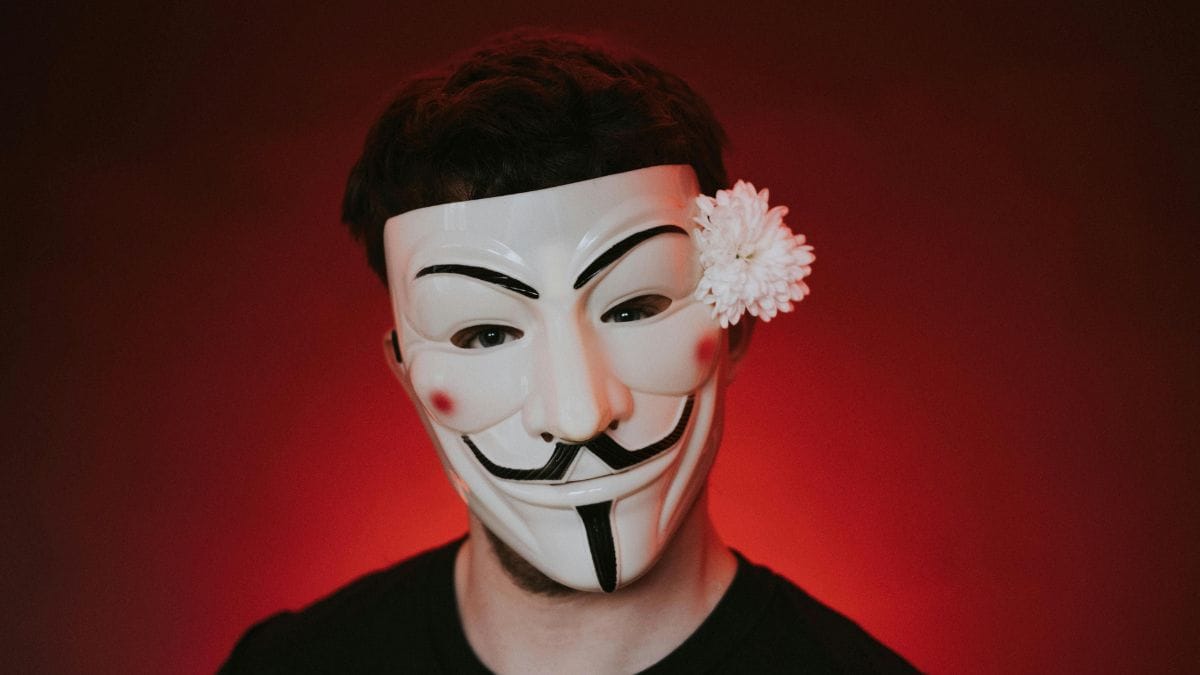 a person with a Guy Fawkes mask on red background