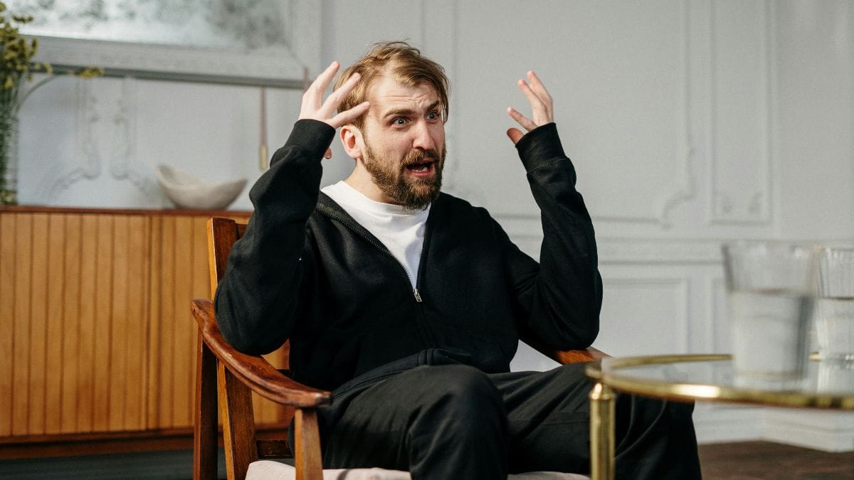 a man with a frustrated face sitting on a chair