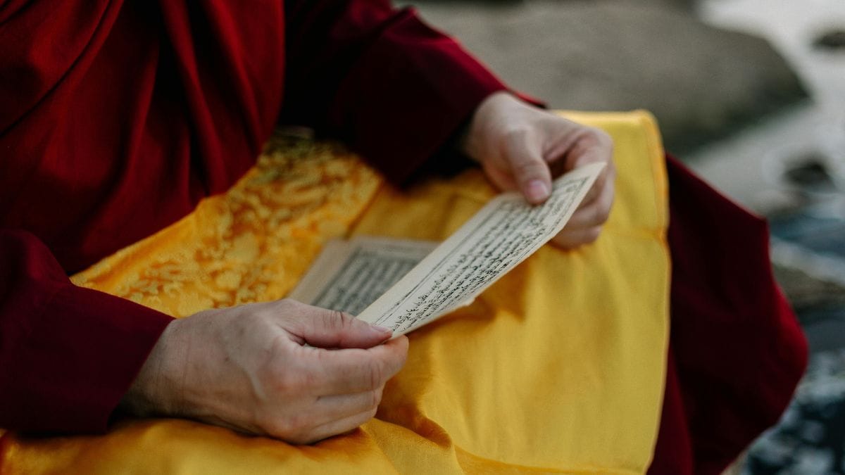 Monk reading ancient manuscript with handwritten text