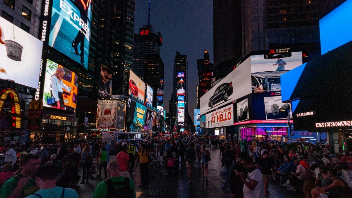 A busy street in the city center with skyscrapers, banners, and lights
